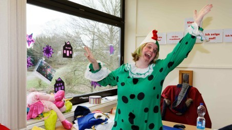 Lehrerin Frau Eichenhofer in einem grünen Clownskostüm