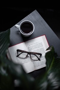 Kaffeepot und ein Buch auf dem eine Brille liegt